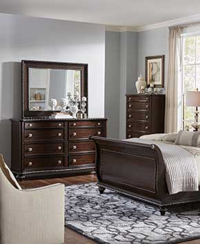 adult bedroom with dark wooden chests and dressers